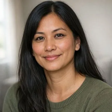 South Asian British woman in her early forties, long dark hair, calm expression
